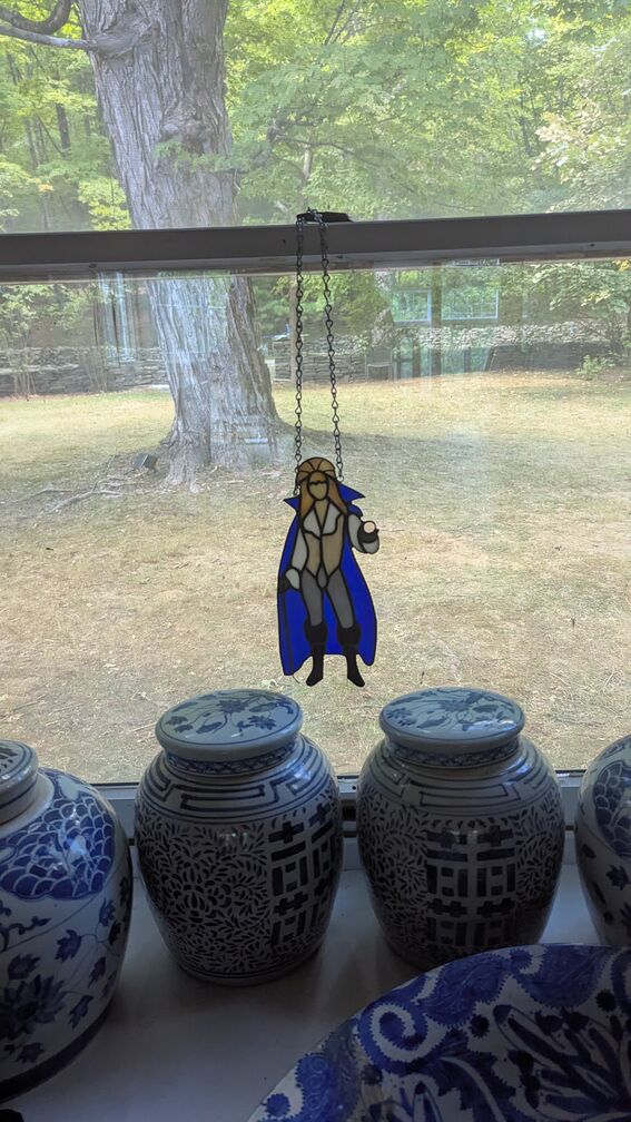 a stained glass ornament of David Bowie, hanging from a kitchen window click for full resolution.
