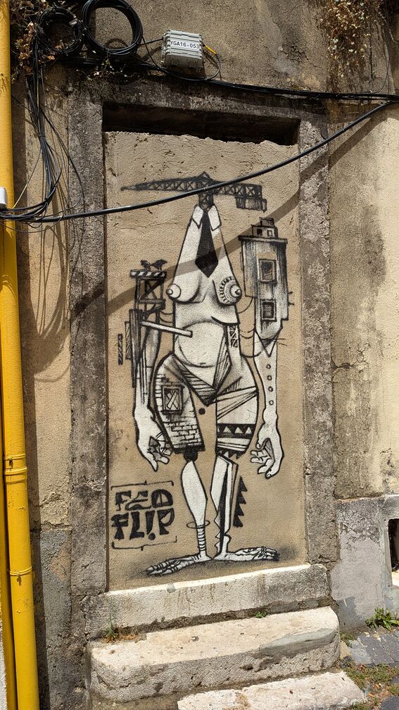 Painted street art from Lisbon, Portugal of a strange humaniod being made of crane's and construction equipment. Feels like a jab at the constant development/gentrification of the city. click for full resolution.