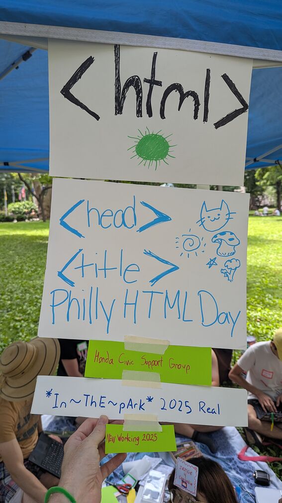 A collection of signs from Philly HTML Day 2025, taped together so they're one large vertical sign. They reads: <html><head><title>Philly HTML Day</title> Honda Civic Support Group. In the park 2025 real. New working 2025.  click for full resolution.