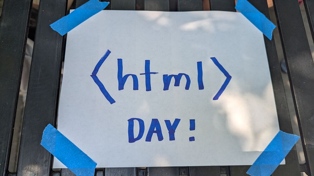 a piece of paper taped to a table that reads: <html> Day!. For the 2026 Philly HTML Day meetup. click for full resolution.