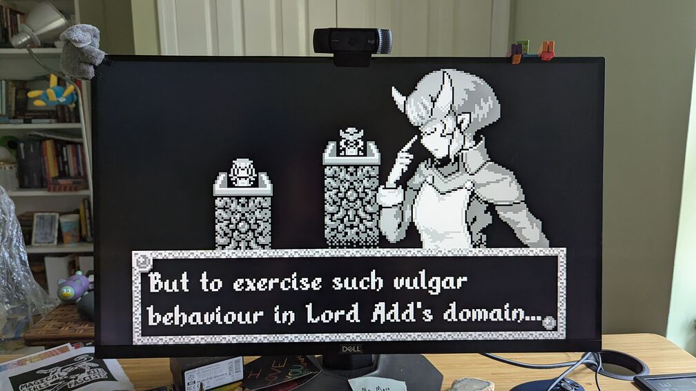 A photo of my computer while I am playing the video game Void Strangers. A bookish character with horns says: "But to exercise such vulgar behavior in Lord Add's domain..." click for full resolution.