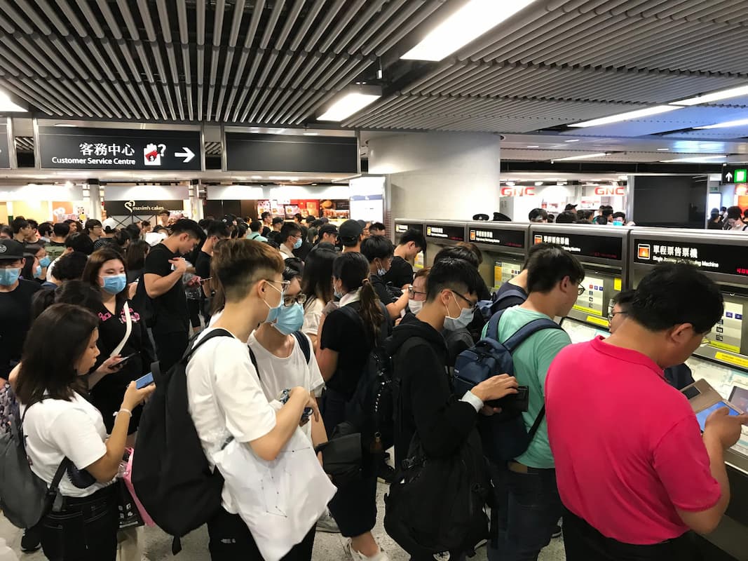 A large group of people waiting in line to buy tickets at a Hong Kong metro station. Photo 
taken from the article linked below.