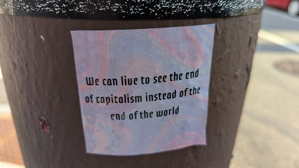 A sticker that reads: we can live to see the end of capitalism instead of the end of the world click for full resolution.