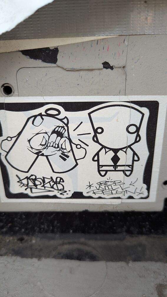 a monster growling at a cartoonish character in a suit, with grafitti tags below click for full resolution.