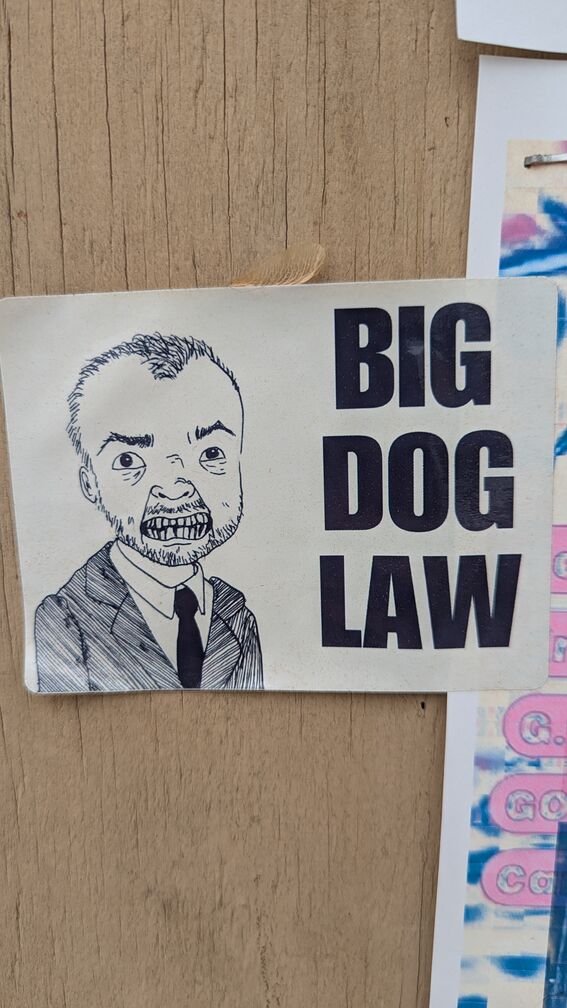 a parody of the Top Dog Law billboards, where a creepy little guy snarls at the viewer and the words Big Dog Law are printed above click for full resolution.