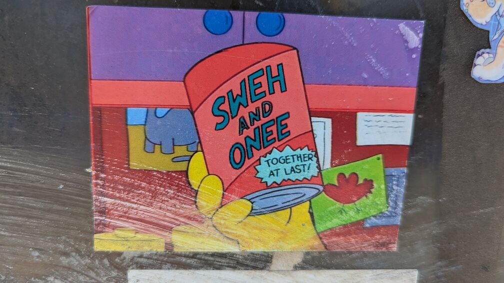 A sticker of a scene from the Simpsons, where Homer holds up a can of food that reads: Sweh and Onee, Together At Last! click for full resolution.
