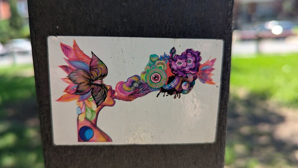 An illustration of a woman with colorful leafs making up her face blowing out a psychadelic puff of smoke. click for full resolution.