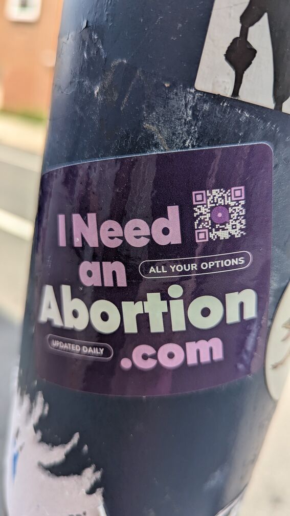 A sticker advertisment for I need an abortion .com click for full resolution.