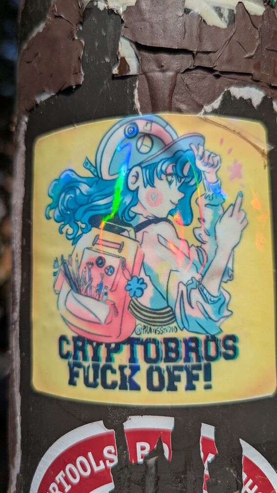 An illustration of an anime-esque blue haired woman wearing a backpack with art supplies flips off the viewer. Text underneath reads 'Cryptobros Fuck Off!'. There's an Instagram handle on the illustration, but I can't quite make it out. click for full resolution.