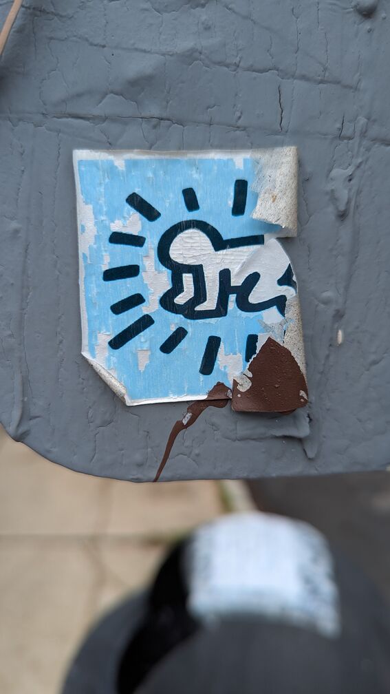 A half-peeled off sticker of somebody in child's pose. click for full resolution.