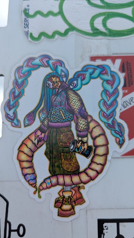 A psychadelic alieen figure with a single eye for a face. They have crazy eye/hair braids that curl around their body. They're holding a spray can. click for full resolution.