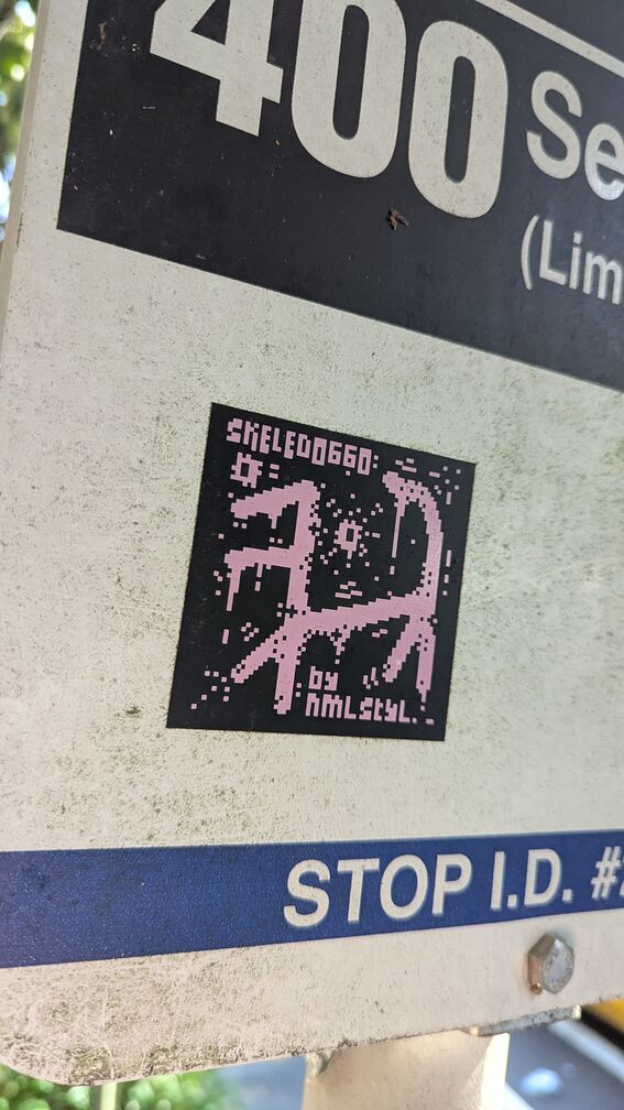 A pixel art sticker of something that looks kinda like the outline of a dog. Text reads skeledoggo, by nmlstyl click for full resolution.