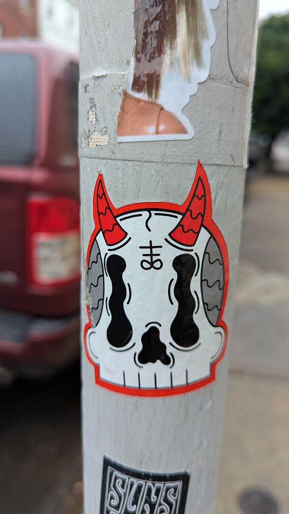 A 1920's style cartoon graphic of a skull with devil horns. The skull has a symbol on its forehead, of an infinity sign with some lines coming out of it, that I'm assuming is the artist's signature. click for full resolution.