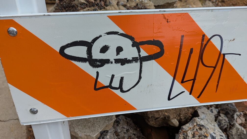 A sad little alien creature drawn on a construction sign. click for full resolution.